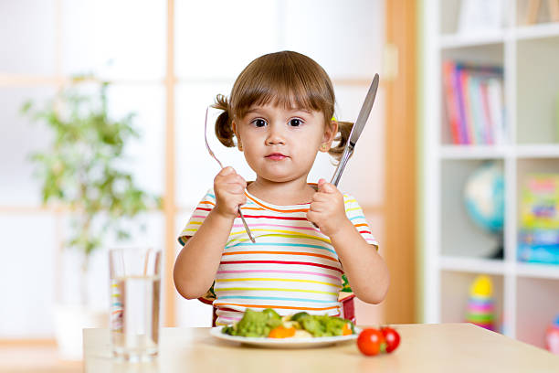 istock little girl with fork and knife ready to eat 544348918