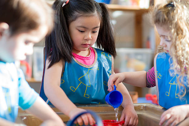 aqua play at nursery - multi ethnic group concentration student asian ethnicity imagens e fotografias de stock