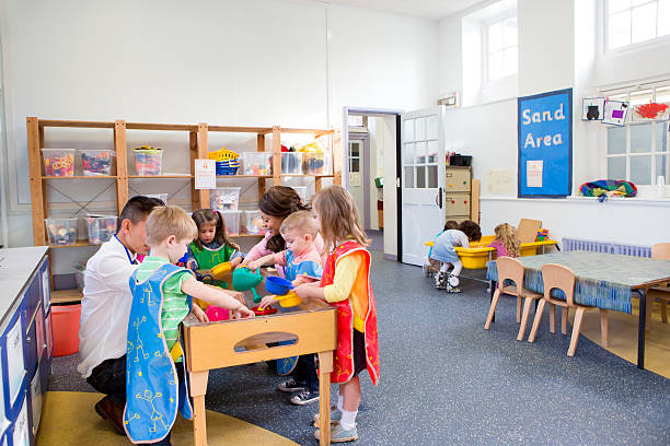 grupo de niños jugando en un aula - parvulario dormitorio fotografías e imágenes de stock