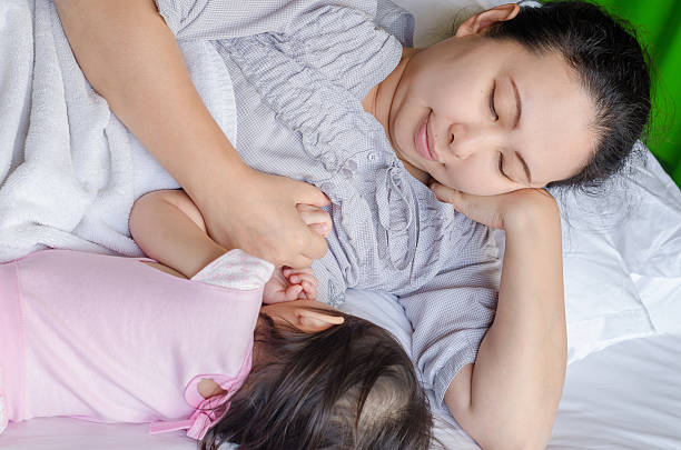 madre l'allattamento al seno suo/a figlio/a - sucking asian ethnicity baby mother foto e immagini stock