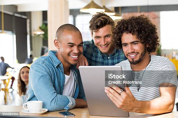 Friends Using Tablet Stock Photo - Download Image Now - Friendship, Digital Tablet, Young Men