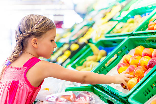 little girl buying healthy foods stock photo