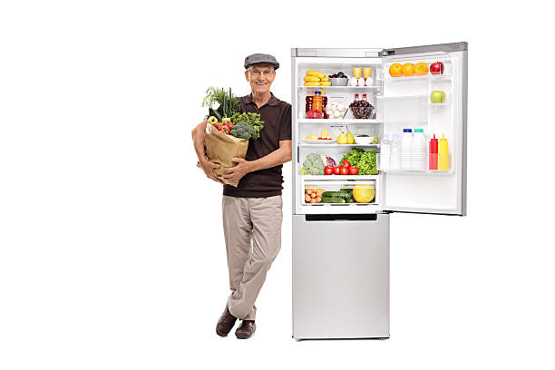 istock Senior holding groceries by a fridge 544444494