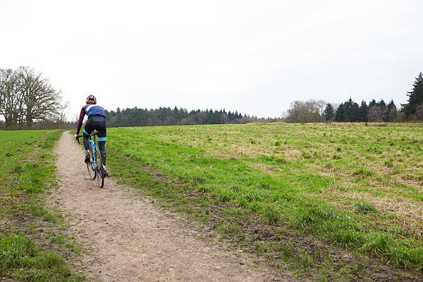 istock Cross-country cyclist on a path in countryside, back view 544445012