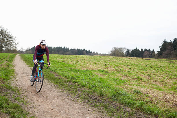 istock Cross-country cyclist riding down a path in open countryside 544445036