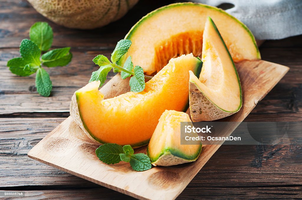 Fresh sweet orange melon and green mint Fresh sweet orange melon and green mint, selective focus Cantaloupe Stock Photo