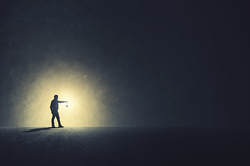 Hombre con lámpara caminando iluminando su camino photo