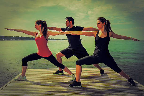 istock Group of people doing yoga at the beach 544456522