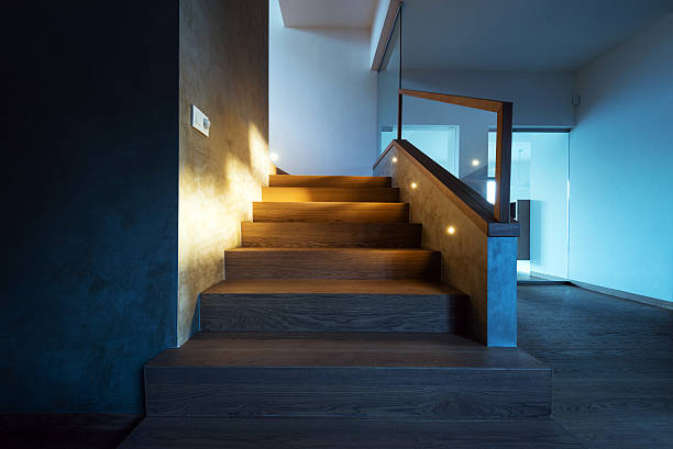 Modern home interior that exudes warmth and simplicity. The wooden staircase leading to the upper level blends seamlessly with the wooden flooring.