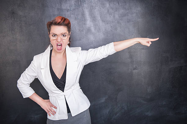 istock Angry screaming teacher pointing out blackboard background 544458452