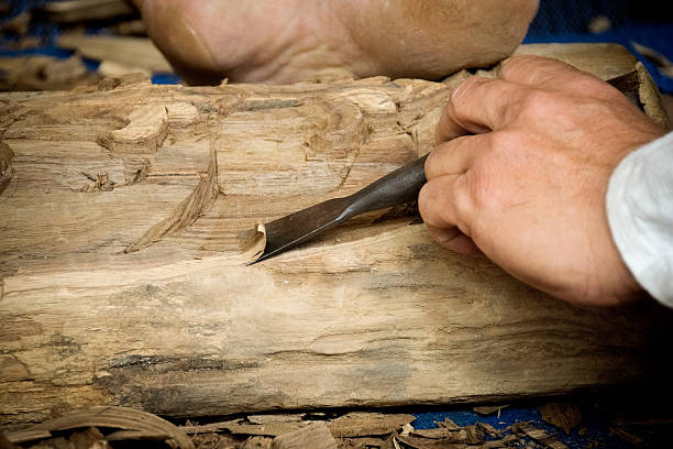 istock Wood carver man is using a wood chisel to extract. 544459606