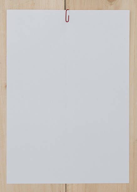 istock white paper with paperclip on wooden background. 544463736