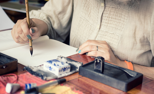 Artist painting in a traditional Japanese technique Sumi-e