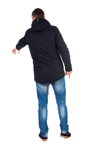 istock Back view of  pointing young men in parka. 544466004