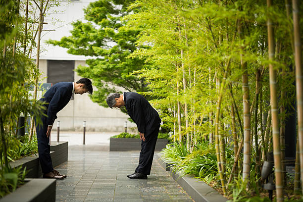Traditional Japanese business greeting Japanese businessmen bowing in traditional Japanese customs used when greeting colleagues and formalizing deals bowing stock pictures, royalty-free photos & images