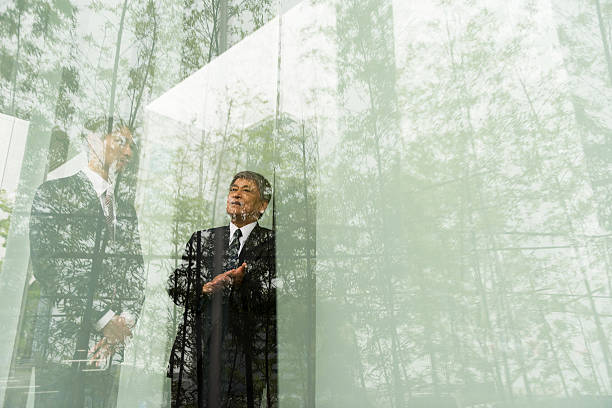 Senior executive and businesman having an outdoor meeting shot through glass