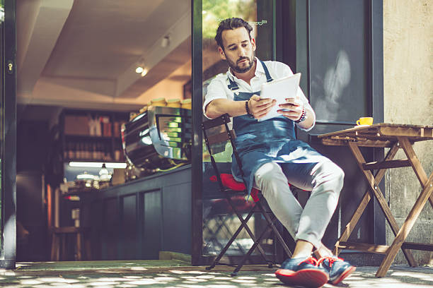 istock Coffee shop owner checking the news 544468326