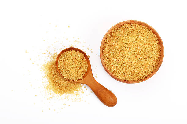 istock Scoop and bowl of brown cane sugar on white 544468956