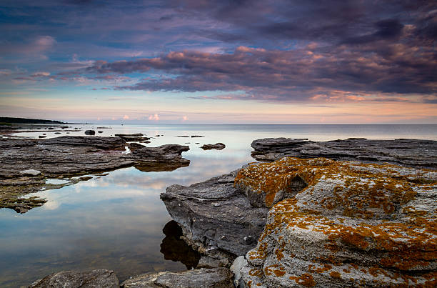Sunrise clouds Sunrise at the ocean with rocks in the foreground gotland stock pictures, royalty-free photos & images