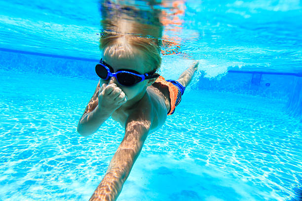 istock little boy learns swimming underwater 544471160
