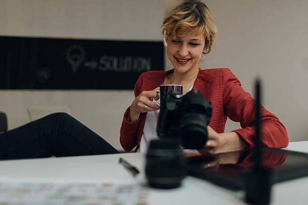 istock Female Photographer Looking Images on her Digital Camera. 544471552