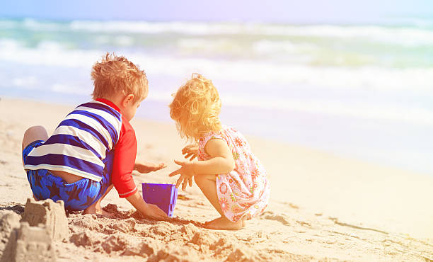istock kids play with sand on summer beach 544472844