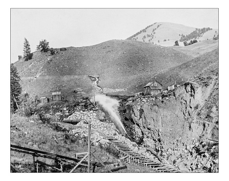 Antique photograph of placer mining scene (mining of stream bed deposits for minerals/gold by water pressure) in California (Usa) during the 19th century. The scene is set in a Californian valley