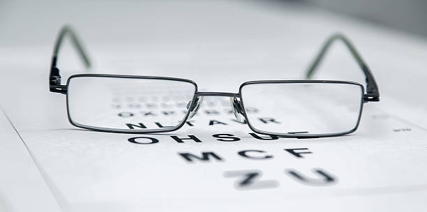 istock Clear Black modern glasses on a eye sight test chart. 544474434