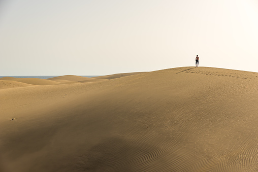 Men walking in the desert on sand dunes of Gran Canaria, Spain
