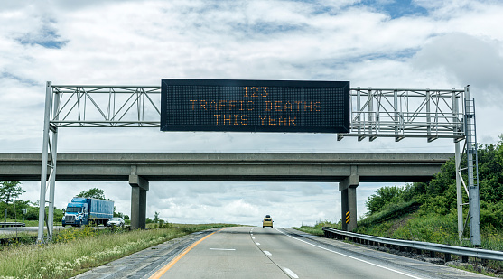An overhead road sign on a rural stretch of western USA expressway highway serves as a warning to motorists - communicating sad, grim statistics. In this case, showing 123 as the total number of traffic deaths in this state so far this year from crashes and accidents.