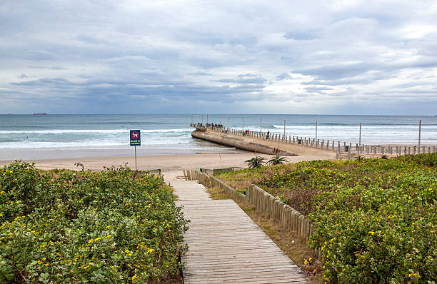 istock Wood Walkway onto Beach with Pier Leading into Sea 544479886