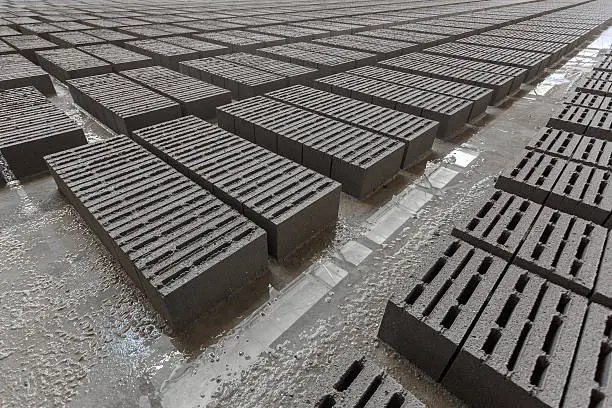 Stack of bricks. Manufacturing of aerated concrete blocks. Manufacturing of cinder block. The plant manufactures building material. The plant produces a cinder block. Cinder block-building material.