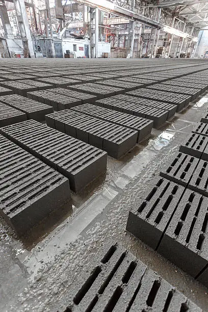 Stack of bricks. Manufacturing of aerated concrete blocks. Manufacturing of cinder block. The plant manufactures building material. The plant produces a cinder block. Cinder block-building material.