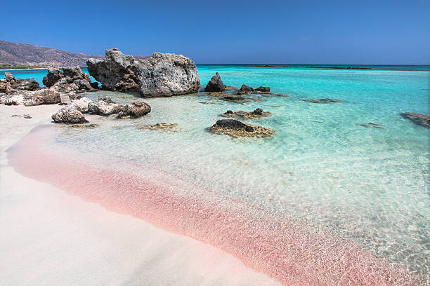 ピンクの砂浜とビーチの海の波 - クレタ島 ストックフォトと画像