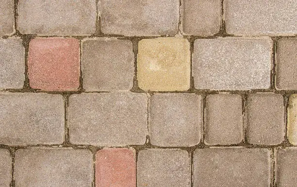 Old paving-stone, gray, pink and yellow. close-up on top of natural light.