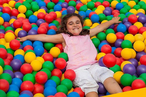istock Girl lie down in a colorful plastic ball pool 544486732