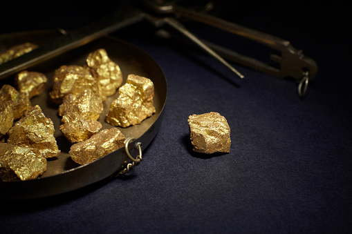 Closeup of big gold nugget and scales copper