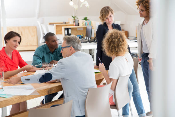 istock Group of office workers talking at desk 544488275