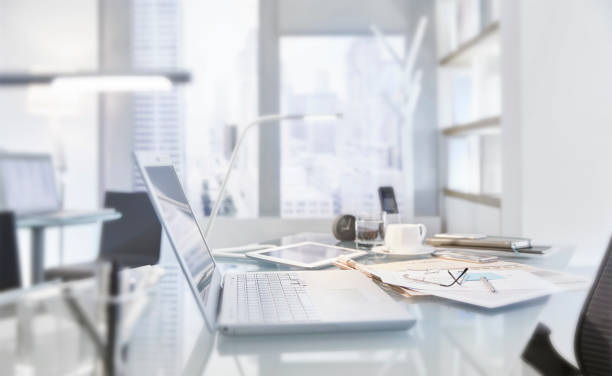 istock Messy table in conference room of modern office with laptop 544488575