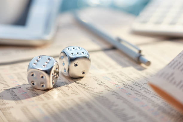 istock Close up of silver dice with sixes on messy desk 544488579