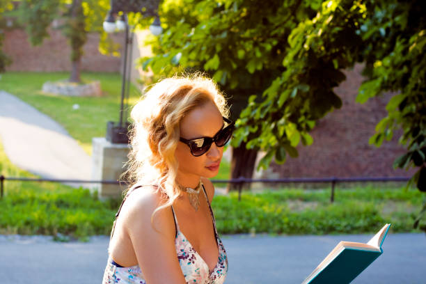 istock Happy woman reading a book during springtime 544488860