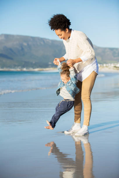istock Mother and daughter playing on beach 544489271