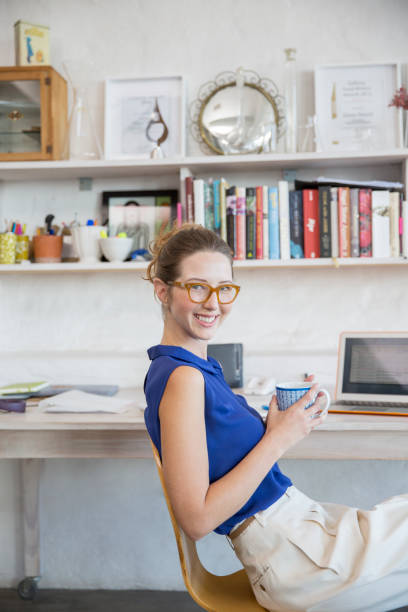 istock Young woman sitting with mug in home office 544489279