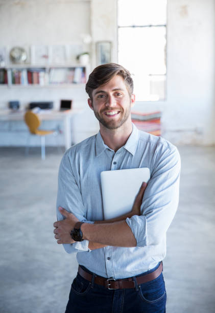 istock Portrait of young man standing in studio with digital tablet 544489343