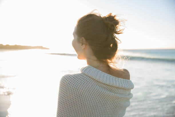 istock Young woman wrapped in blanket on beach 544489431