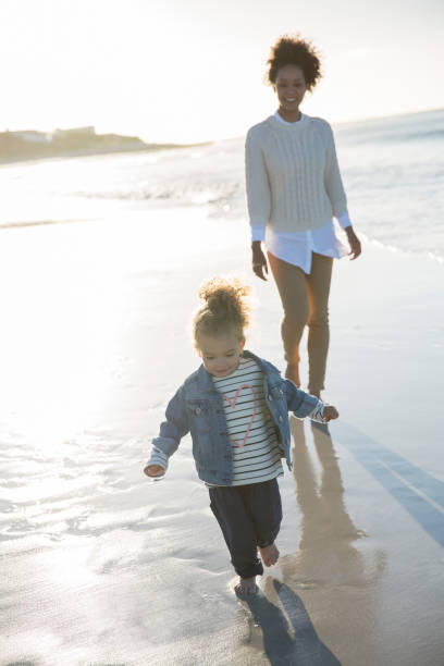 istock Mother and daughter walking on beach 544489451
