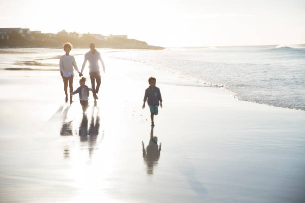 istock Family walking on beach at sunset 544489765