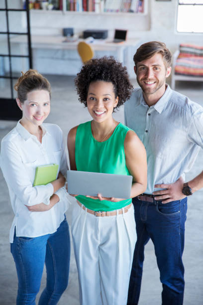 istock Portrait of three young people standing with digital tablet in studio 544489831