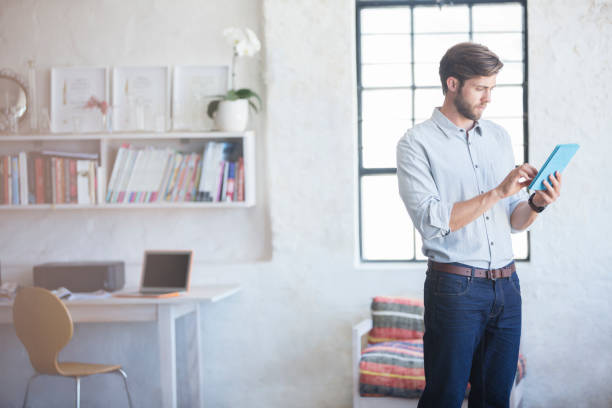 istock Man with digital tablet standing in home office 544489851