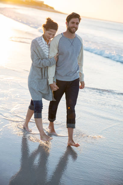 istock Young couple walking on beach in evening sun 544489873